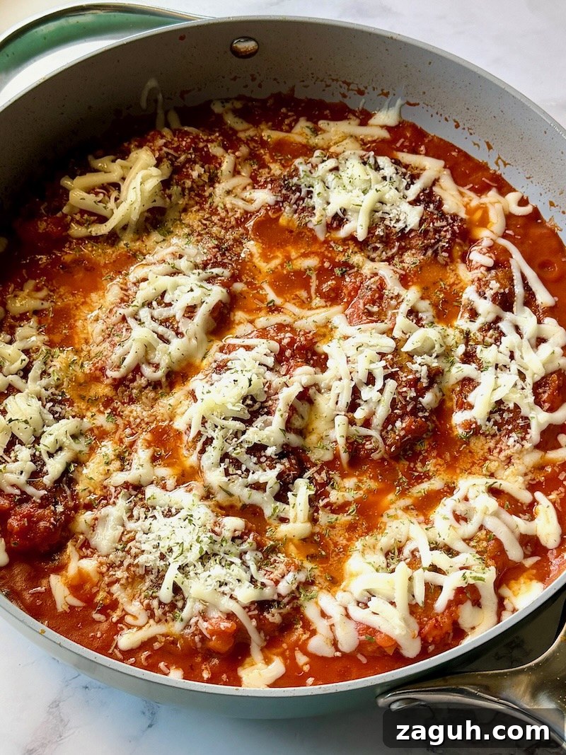 25-Minute Chicken Parmesan Recipe for Busy Family Dinners 11 Chicken parmesan cooked in a skillet with melted cheese on top.