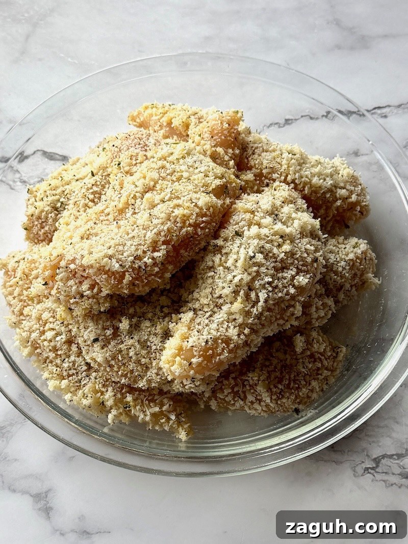 25-Minute Chicken Parmesan Recipe for Busy Family Dinners 8 chicken tenders breaded on a plate.