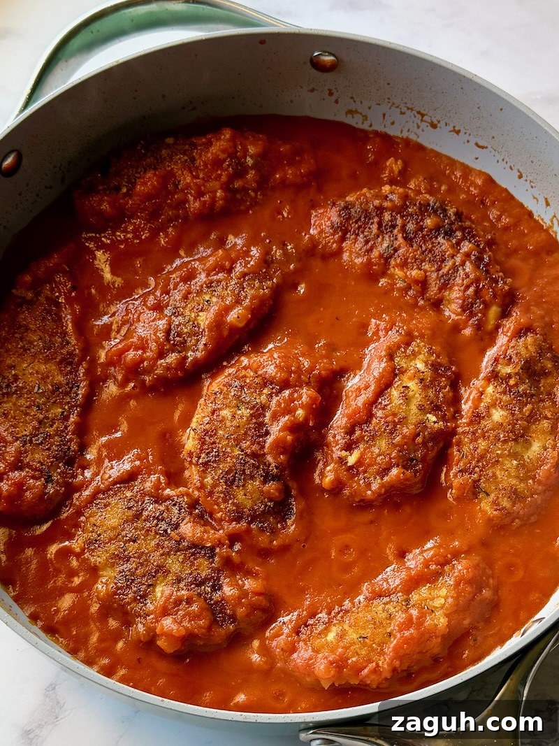 25-Minute Chicken Parmesan Recipe for Busy Family Dinners 10 Pasta sauce in the pan with the chicken tenders.
