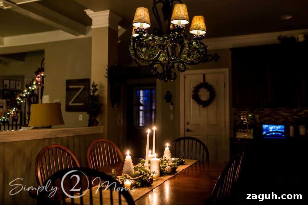 Classic Christmas Candlelight Tour You Have to See This Year 20 table with Christmas centerpiece lit by candles, chandelier decorated with ivy and red berries