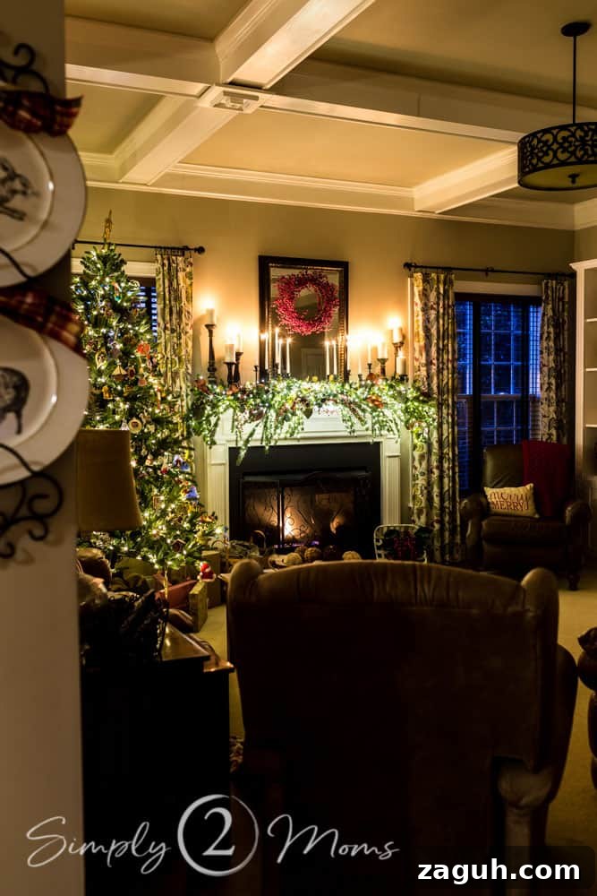 Classic Christmas Candlelight Tour You Have to See This Year 21 family room view with Christmas tree and lit fireplace decorated for Christmas with candle, greenery, and red berries