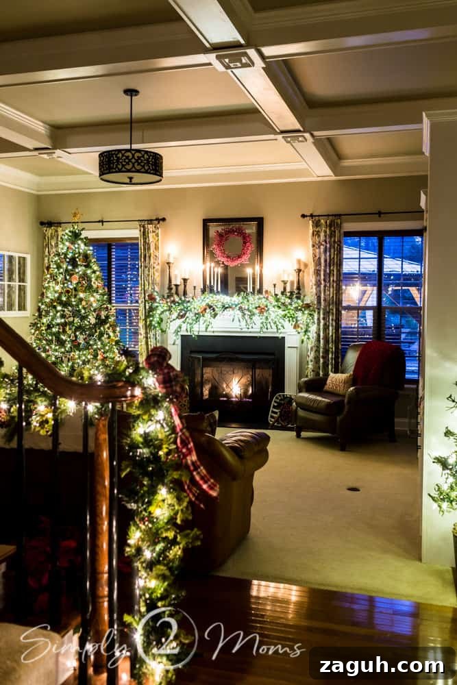 Classic Christmas Candlelight Tour You Have to See This Year 6 family room view with Christmas tree and lit fireplace decorated for Christmas with candle, greenery, and red berries