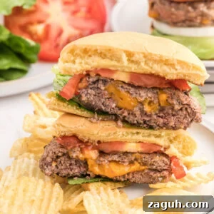 A Blackstone Cheese Stuffed Burger cut in half reveals melted cheese inside the beef patty.