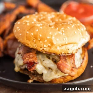 A bacon cheeseburger with sweet potato fries.