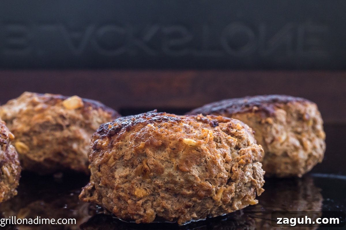 Cooked ground beef patties on the griddle