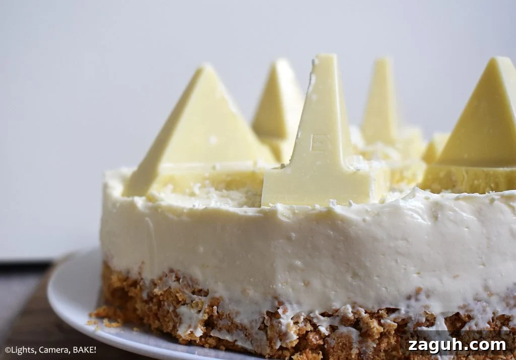White Chocolate Toblerone Cheesecake Recipe — Creamy No-Bake Slice 4 Side view of half of a White Chocolate Toblerone Cheesecake with a white background.