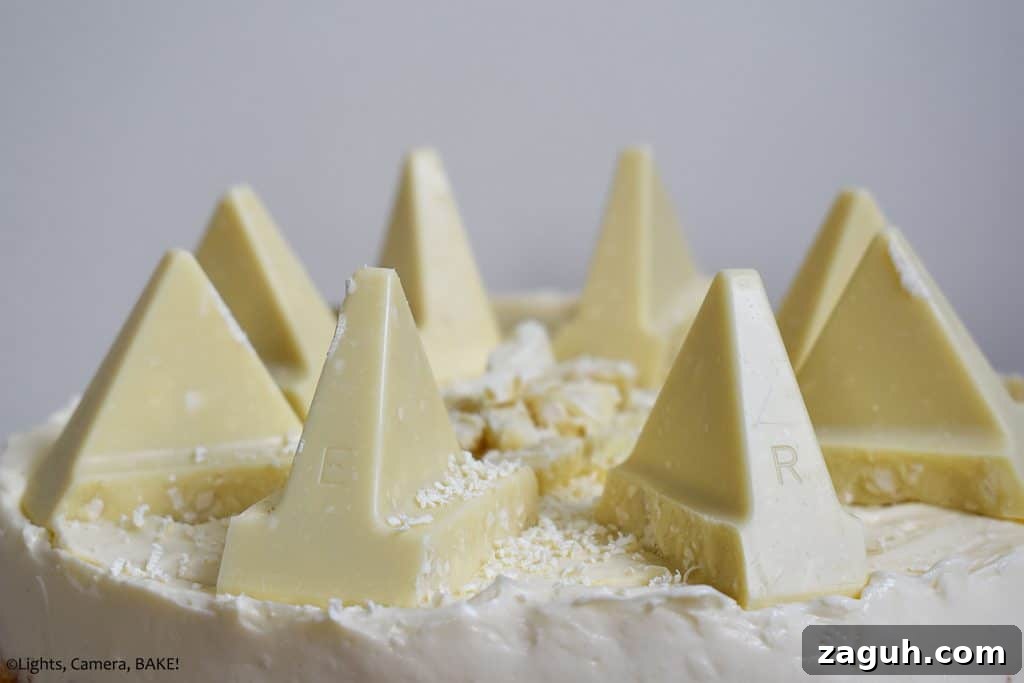 White Chocolate Toblerone Cheesecake Recipe — Creamy No-Bake Slice 6 Pieces of toberlone on top of a white chocolate cheesecake with a white background.