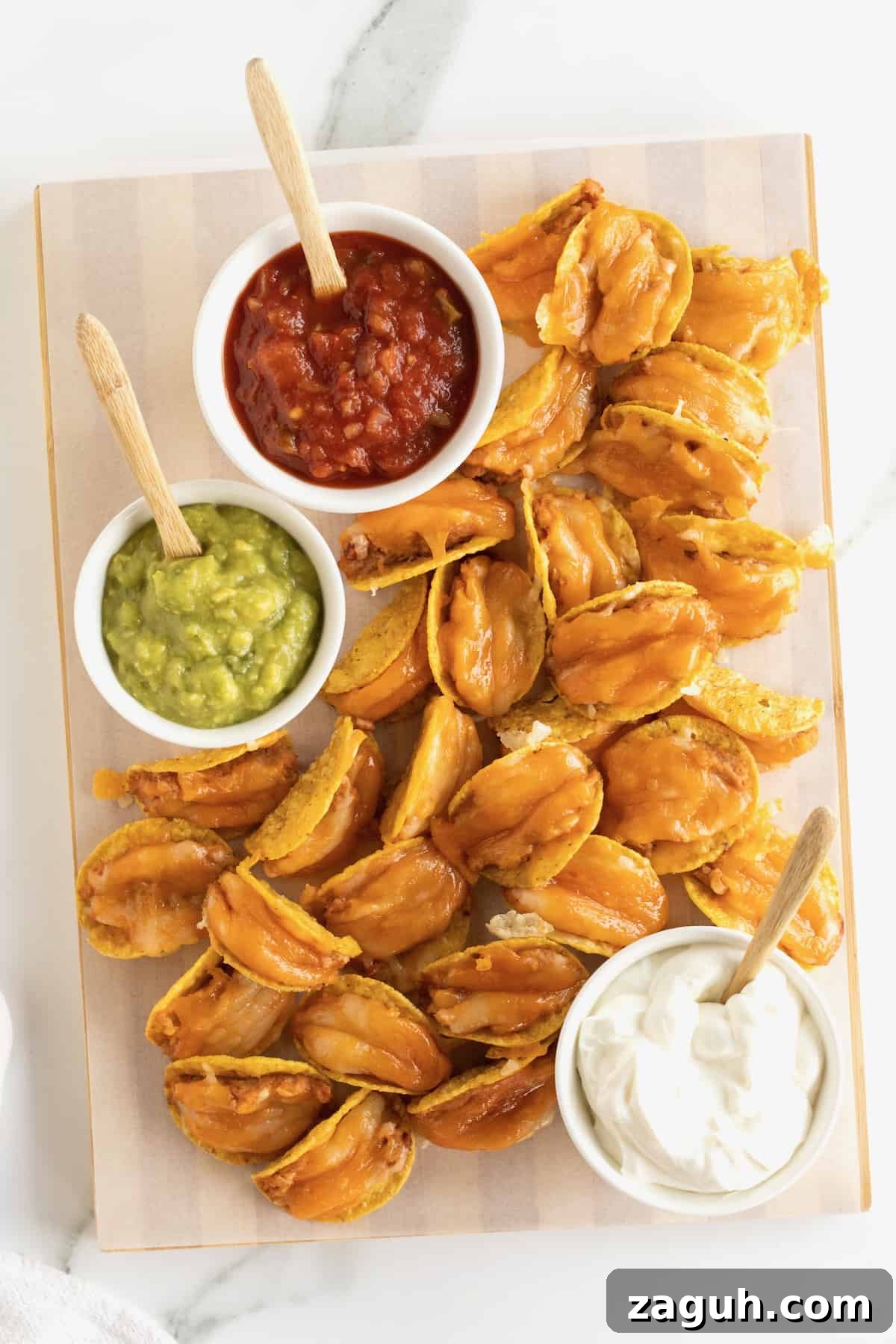 Authentic Mexican Fiesta Recipes for Your Party Menu 15 Taco bites made out of tortilla chips, refried beans and cheese served with a bowl of guacamole, sour cream and a bowl of salsa.