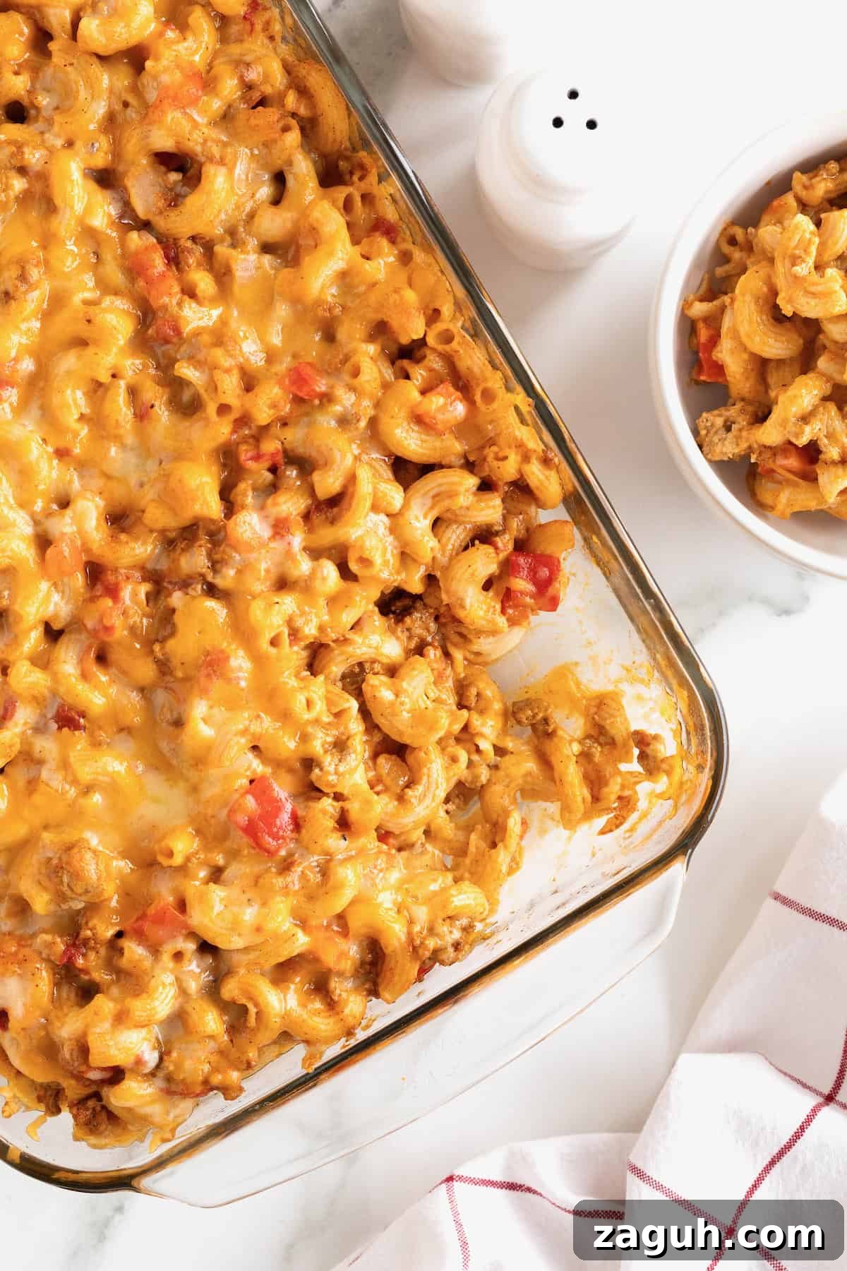 Authentic Mexican Fiesta Recipes for Your Party Menu 28 A glass casserole dish with Mexi Mac and cheese on a white marble counter.