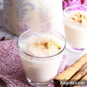 Refreshing Horchata Agua Fresca Recipe: Traditional Mexican Rice Drink 10 Two glasses of horchata agua fresca with a pitcher behind it