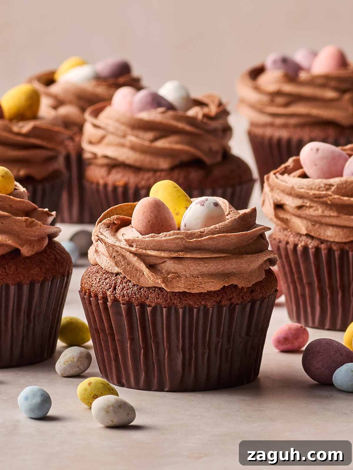 Decadent Chocolate Easter Cupcakes with Spring Decorations 2 A batch of Chocolate Cupcakes from these side, with Cadbury's Mini Eggs on top and some scattered on the surface beneath.