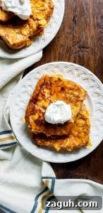 Crispy Buttermilk French Toast Two white plates with french toast and whipped cream on a dark wooden surface.