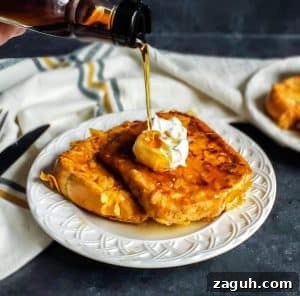 Crispy Buttermilk French Toast French toast on a white plate with syrup being poured on top.