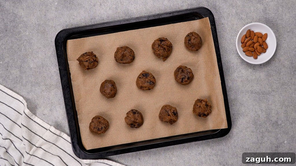 Almond Flour Chocolate Chip Cookie Recipe — Soft & Chewy</assistant 9 A baking sheet lined with parchment paper, holding evenly spaced cookie dough balls.