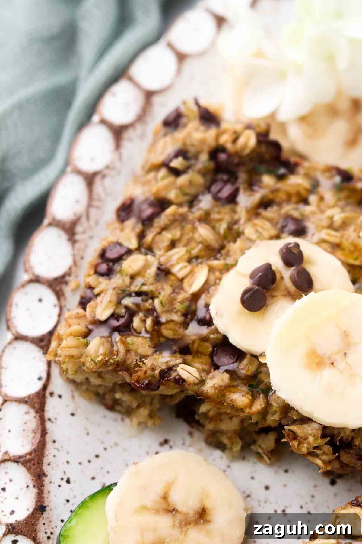 zucchini oatmeal bars 1 2 1 Zucchini chocolate chip oatmeal bars on a plate with fresh banana and chocolate chips.