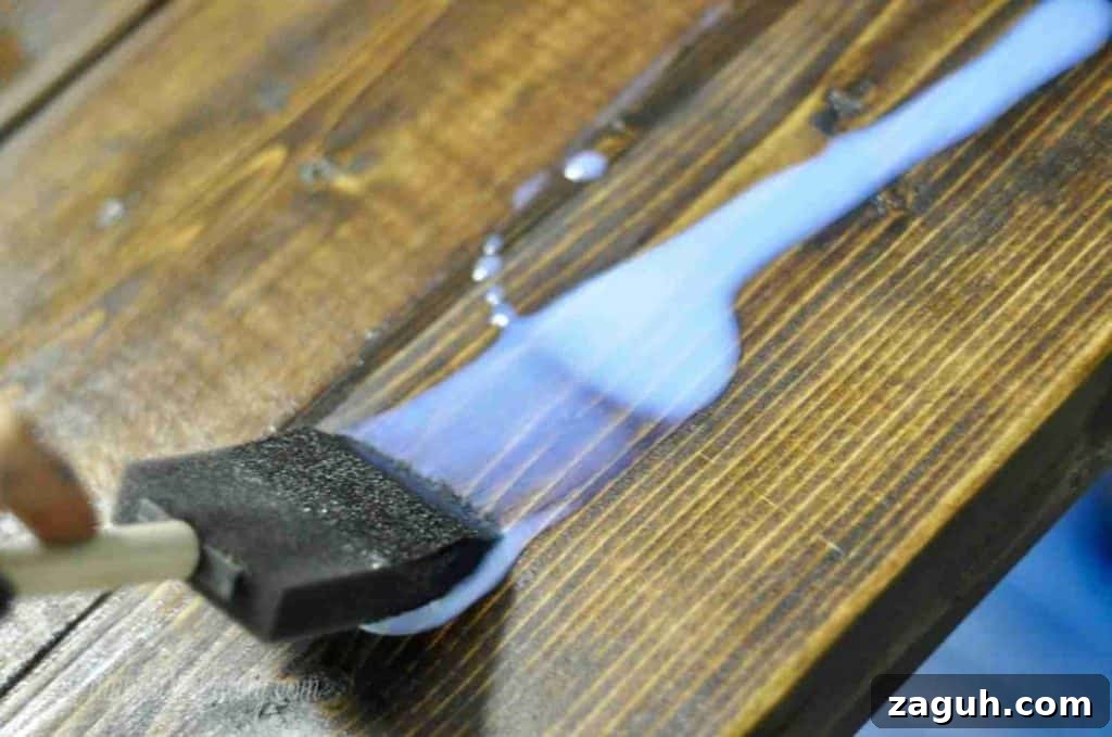 DIY Console Table Plans: Step-by-Step Build Guide and Dimensions 16 painting polycrylic onto a wood table.