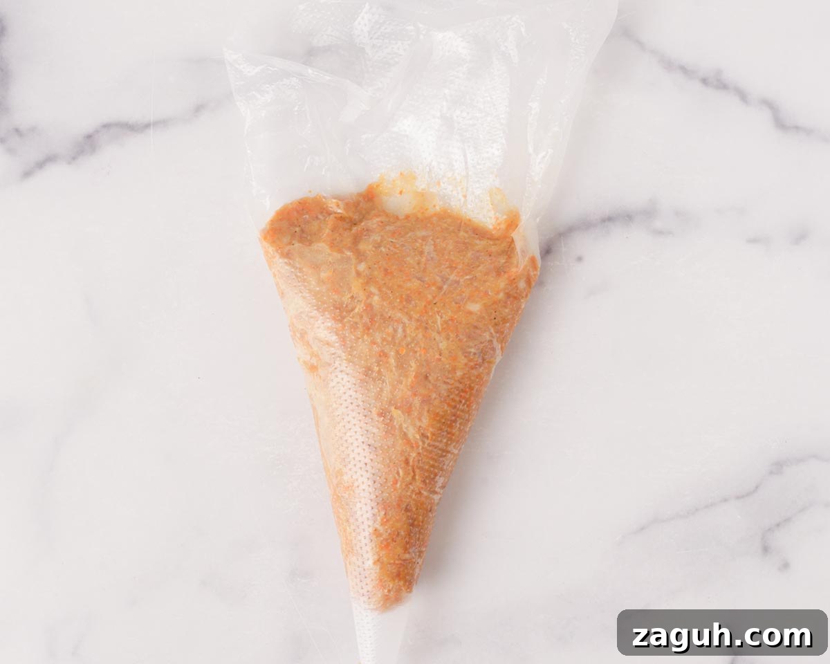Filipino Lumpia: Classic Crispy Spring Rolls Recipe 11 Placing lumpia filling into a piping bag.
