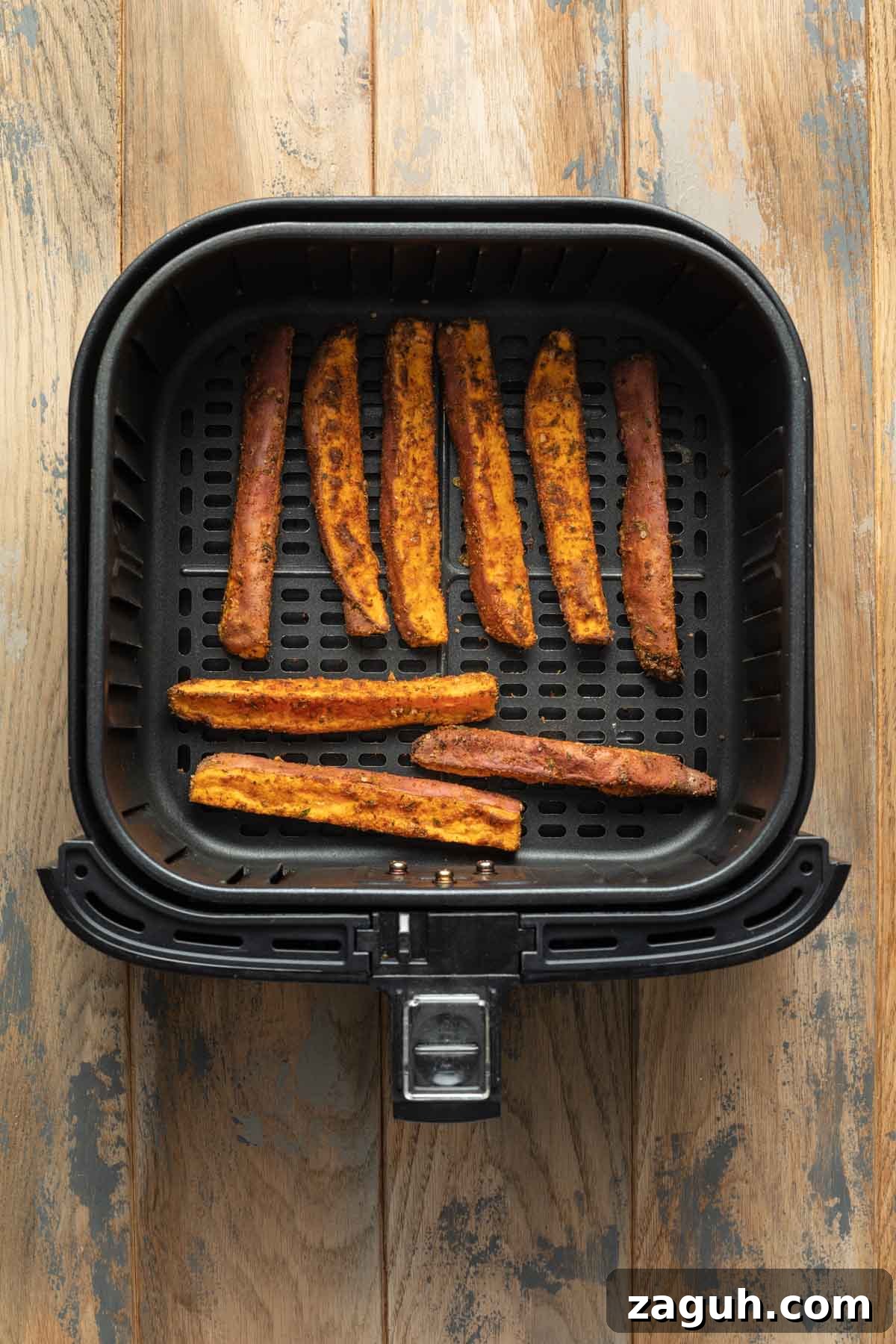 Crispy Air Fryer Sweet Potato Wedges Recipe 7 Air fried sweet potato wedges in an air fryer basket.