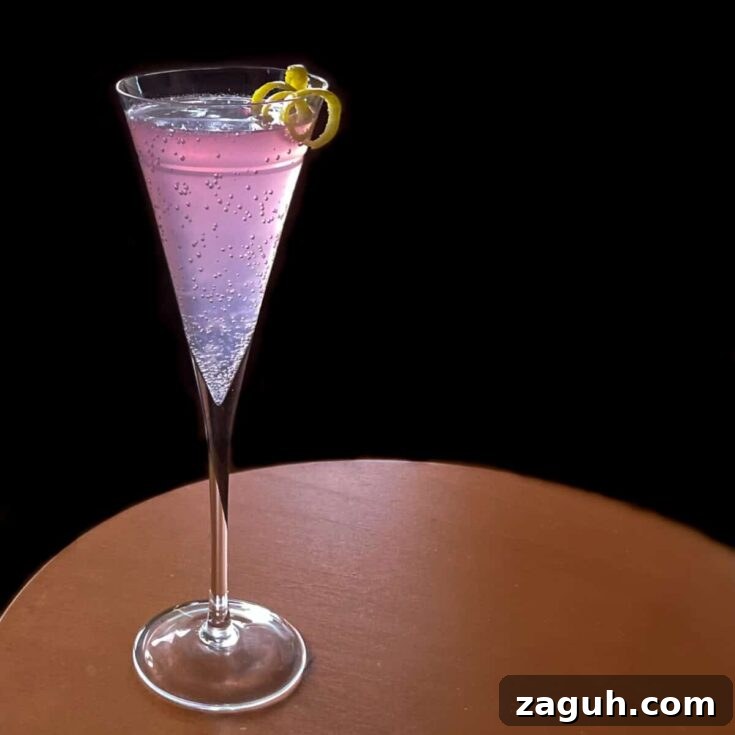 A purple rose syrup French 75 on a black background.
