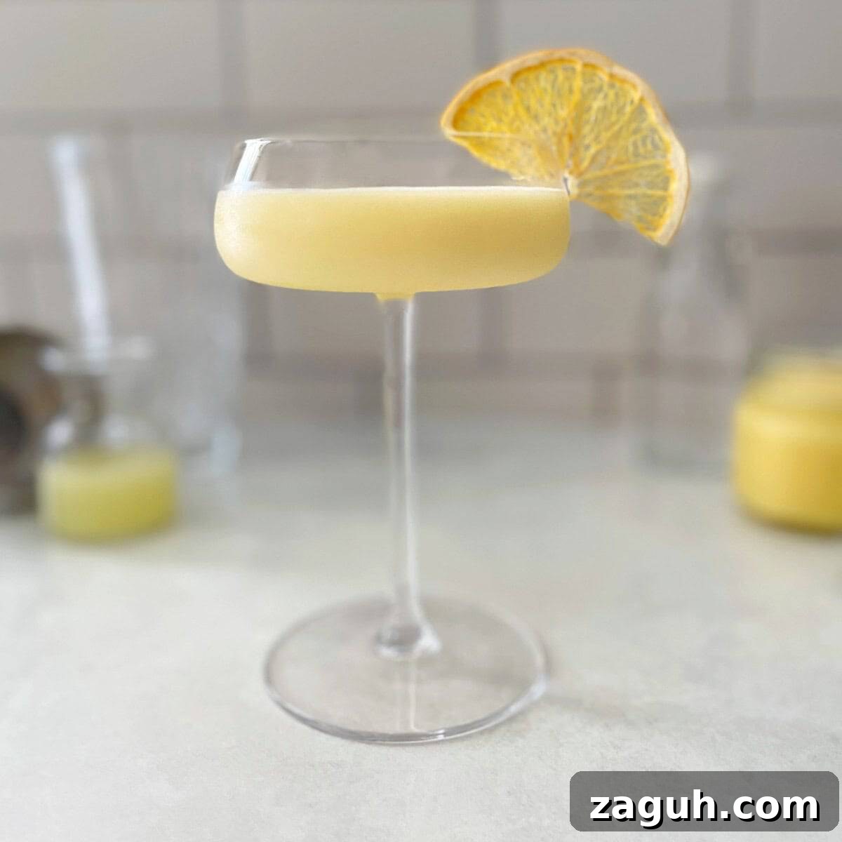 A lemon curd cocktail garnished with a lemon slice.