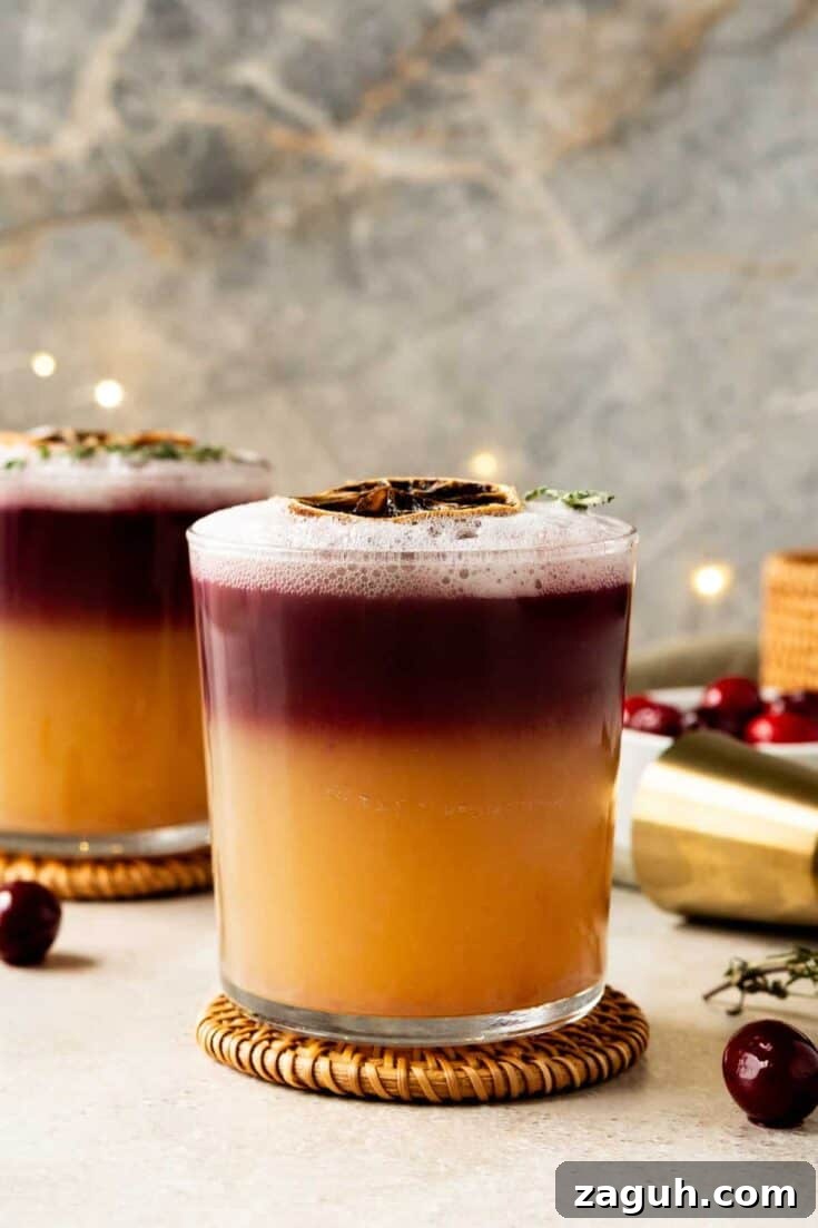 A Christmas New Yor Sour cocktail with christmas lights in the background.