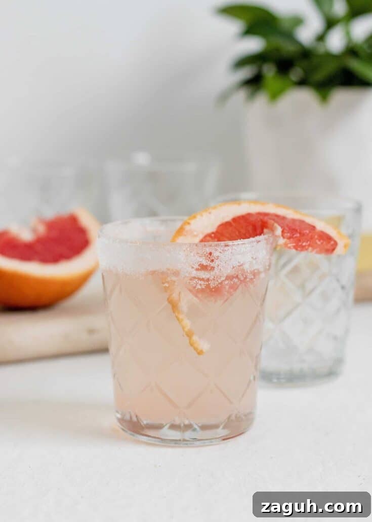 A grapefruit and rum cocktail garnished with a slice of grapefruit.