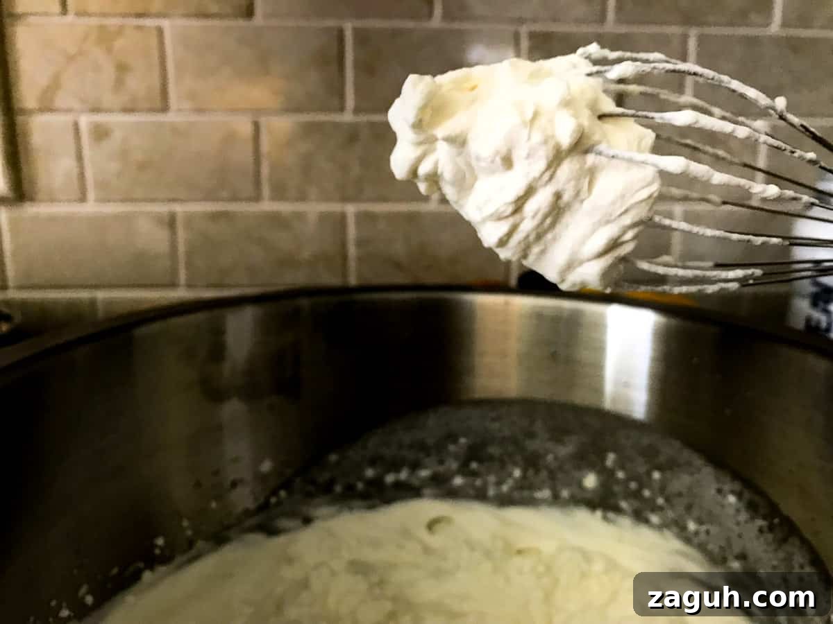 No-Bake Coconut Cream Pie Recipe — Silky Coconut Custard Pie 3 Whipped cream on a metal whisk