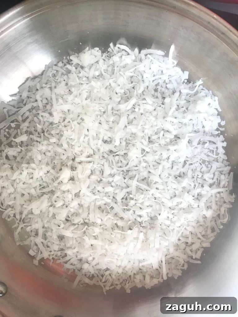 No-Bake Coconut Cream Pie Recipe — Silky Coconut Custard Pie 4 Shredded coconut in skillet.
