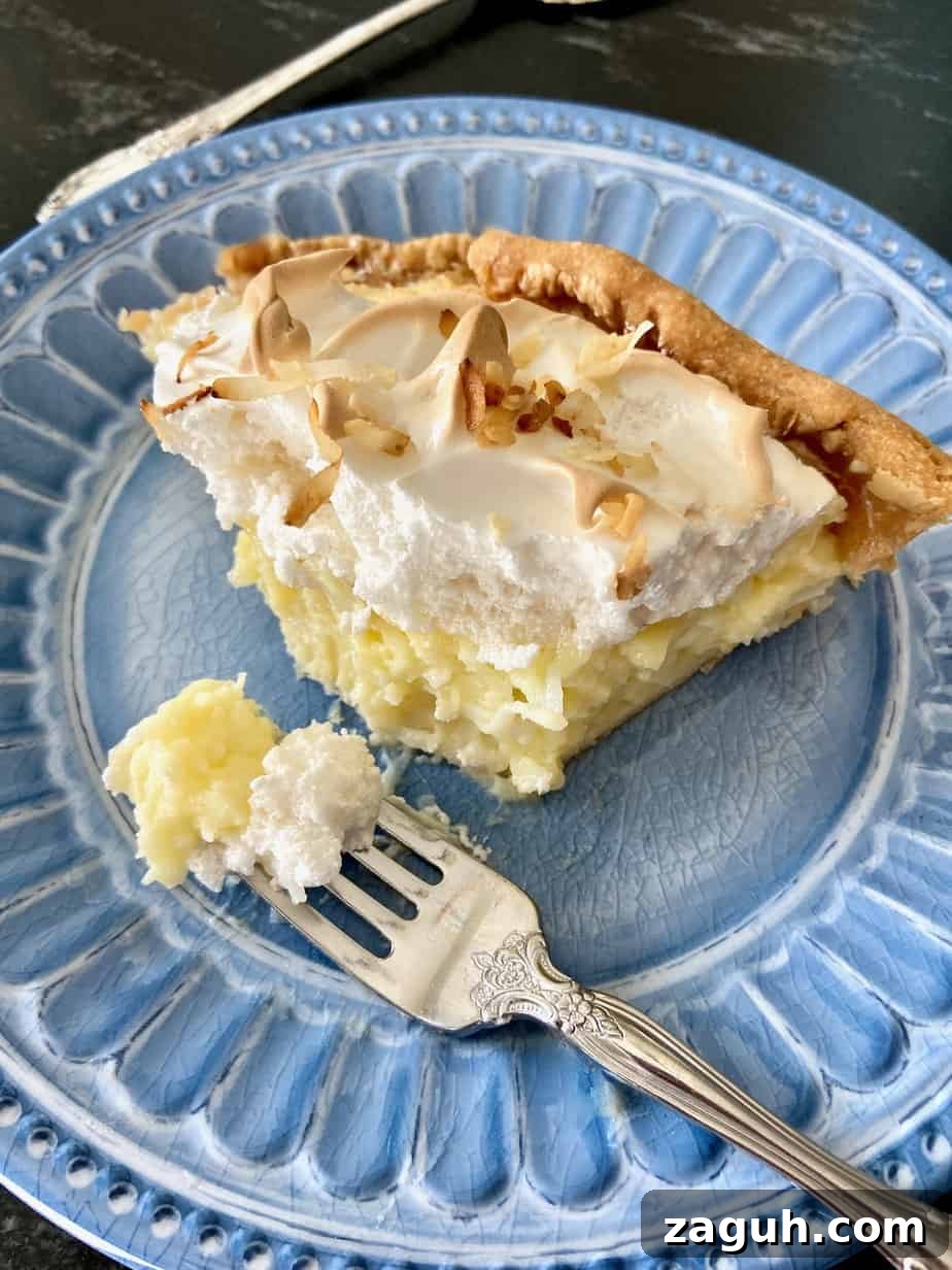 No-Bake Coconut Cream Pie Recipe — Silky Coconut Custard Pie 6 Slice of pie with a bite on fork.