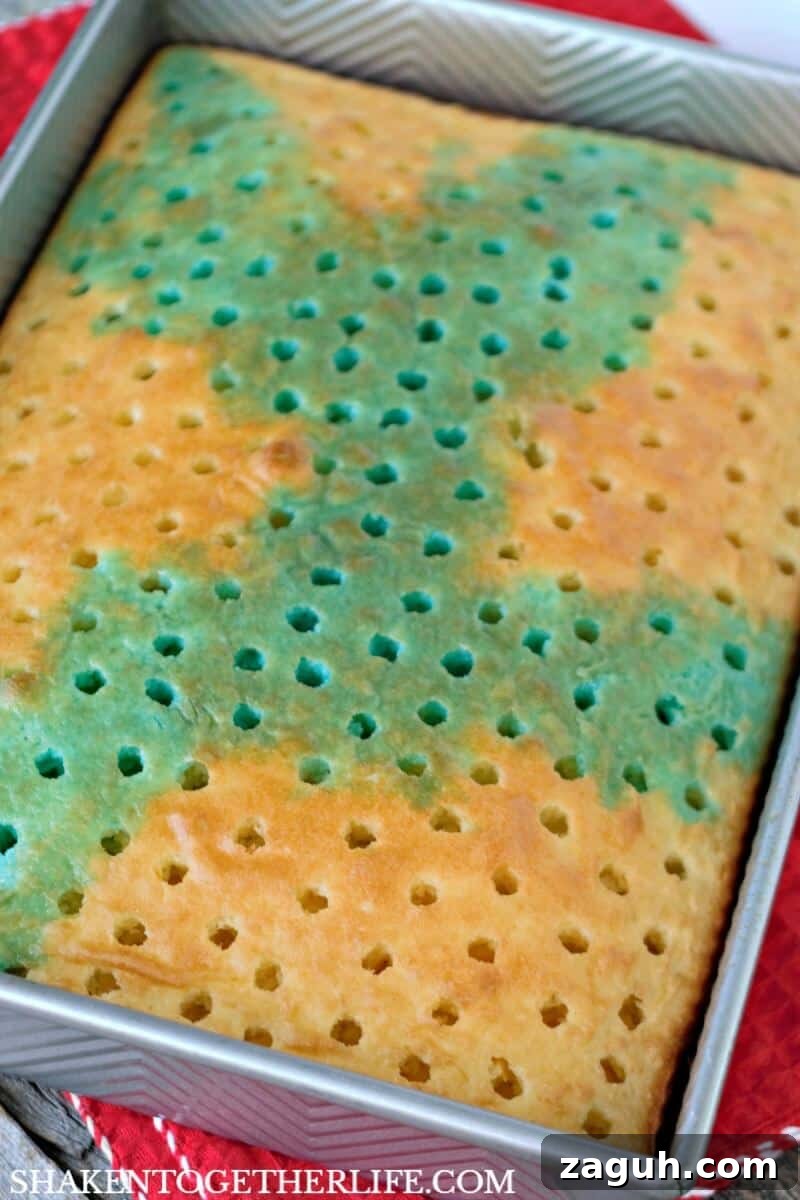 Carefully spoon blue Jell-o over a portion of the cake for our Red, White & Blue Poke Cake