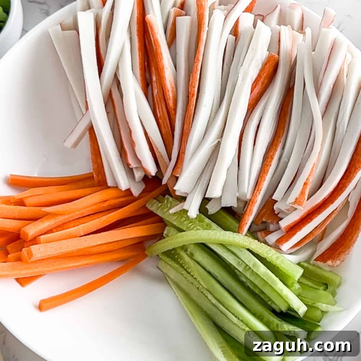 Kani Salad Recipe: Japanese Crab Stick Salad with Sesame Dressing 4 Julienned carrots, cucumbers and crab in a bowl.