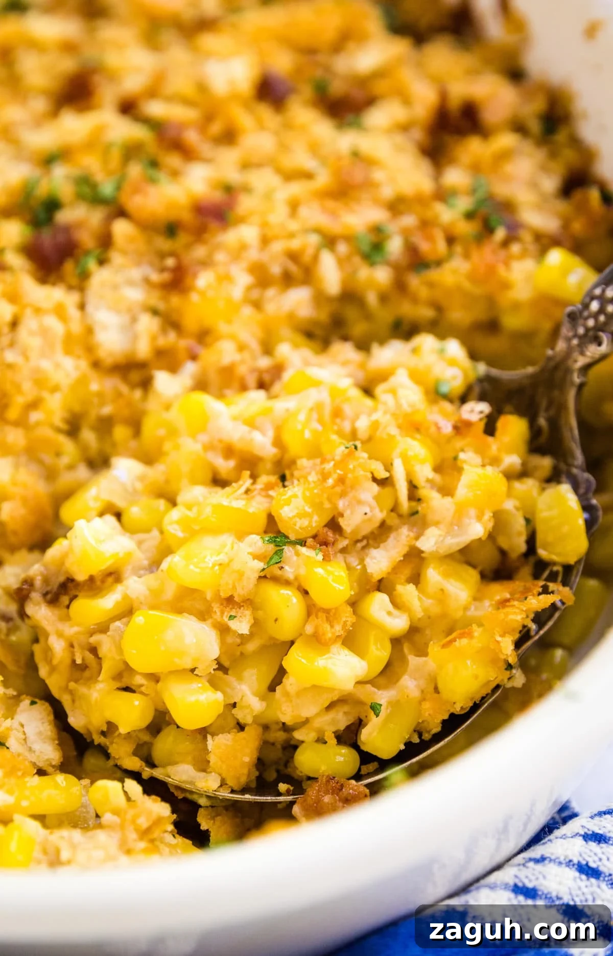 Creamy Corn Pudding Casserole Recipe for Comforting Sides 2 A close up image of a serving spoon holding a scoop of corn pudding in the pan of it.