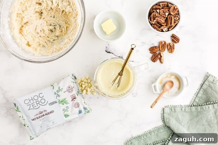 Keto White Chocolate Pecan Fudge — 2g Net Carbs Per Serving 5 melted keto fudge cream cheese white chocolate chips in a small bowl next to other ingredients