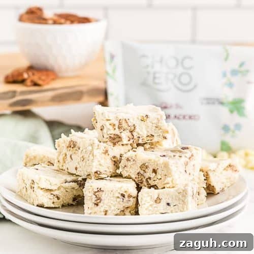 Keto White Chocolate Pecan Fudge — 2g Net Carbs Per Serving 9 side view of stacked plates with keto fudge with pecans