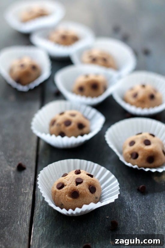 These Chocolate Peanut Butter Cookie Dough Balls taste just like classic chocolate chip cookie dough, but they’re no-bake, bite-sized, and quick to make. Peanut butter cookie dough balls topped with mini chocolate chips and served in mini cupcake wrappers.