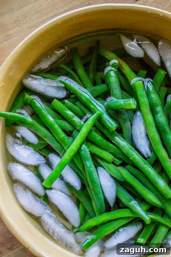 Make-Ahead Garlic Green Beans with Almonds and Crispy Breadcrumbs 4 Green beans blanching in ice water bath.