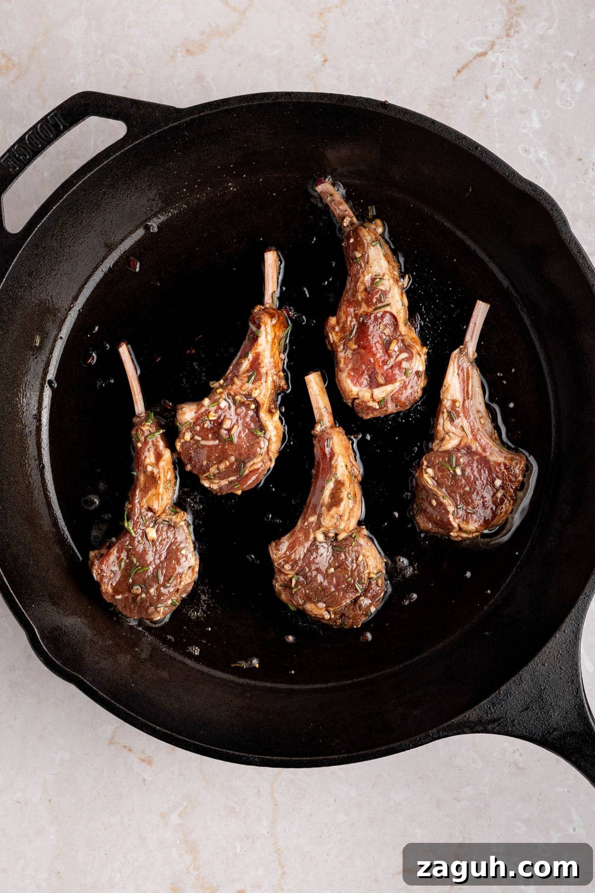 Balsamic-Glazed Oven-Baked Lamb Chops for Weeknight Dinner 5 The lamb chops searing in a hot cast iron pan.