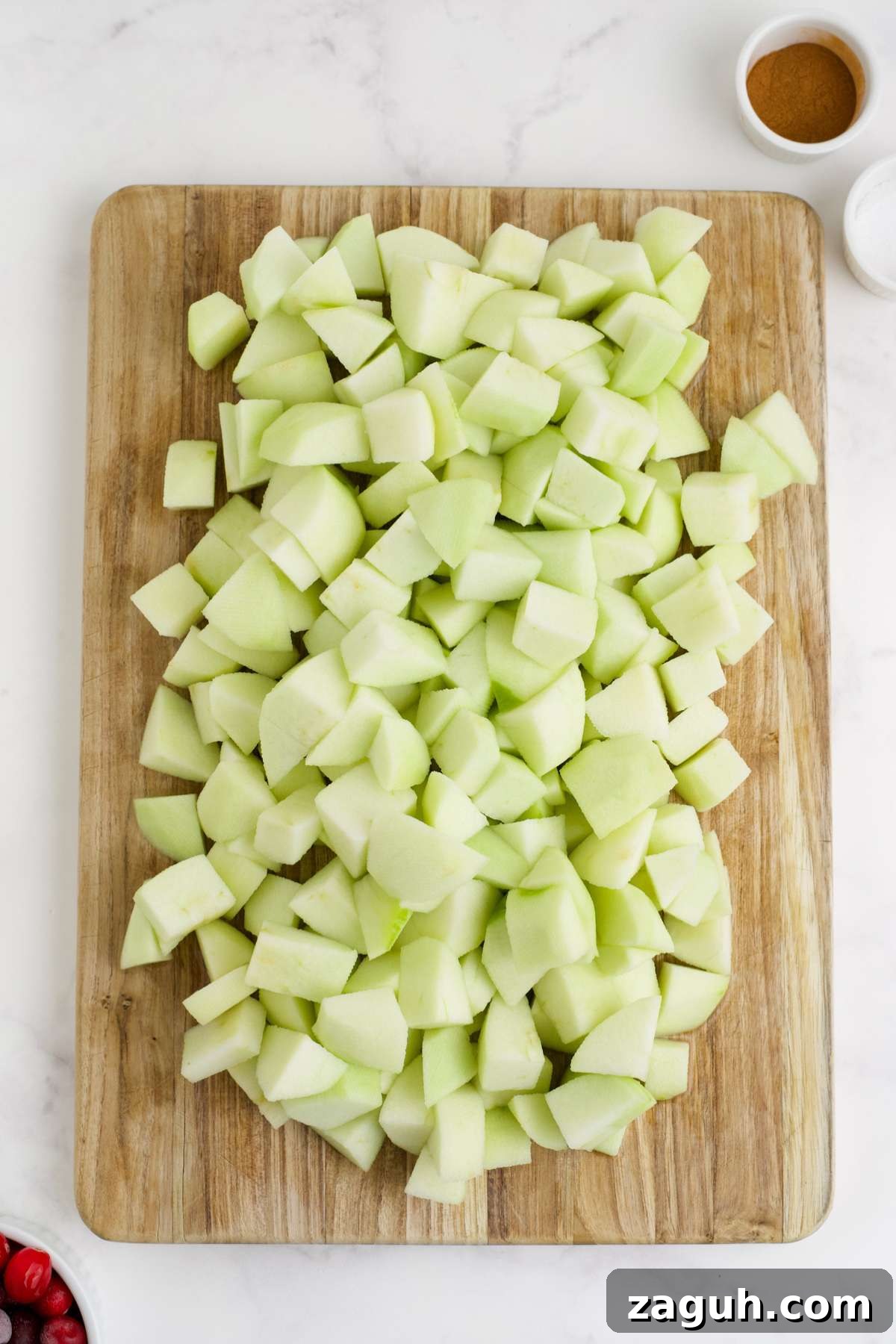 Cranberry Apple Sauce Recipe: Tangy Homemade Spread for Fall 4 Apples peeled and diced on a wooden cutting board.