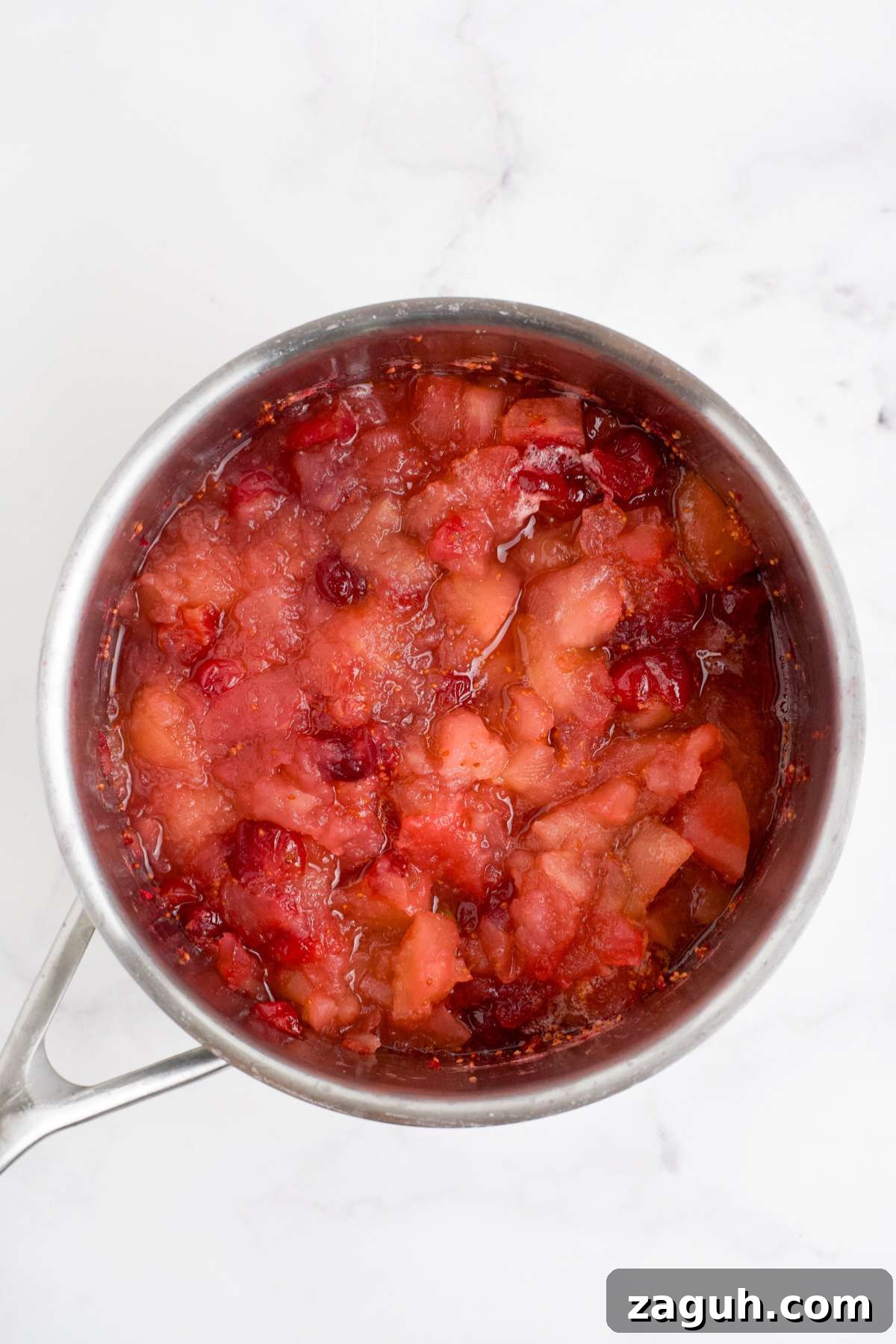 Cranberry Apple Sauce Recipe: Tangy Homemade Spread for Fall 6 Cranberries and apples cooked and mashed in a saucepan.