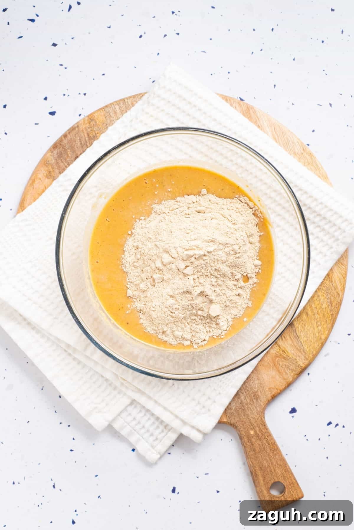 Overhead view of mixed chickpeas, oil, nutritional yeast, soy sauce, onion powder, garlic powder, poultry seasoning, and miso paste added with wheat gluten placed on a transparent bowl.