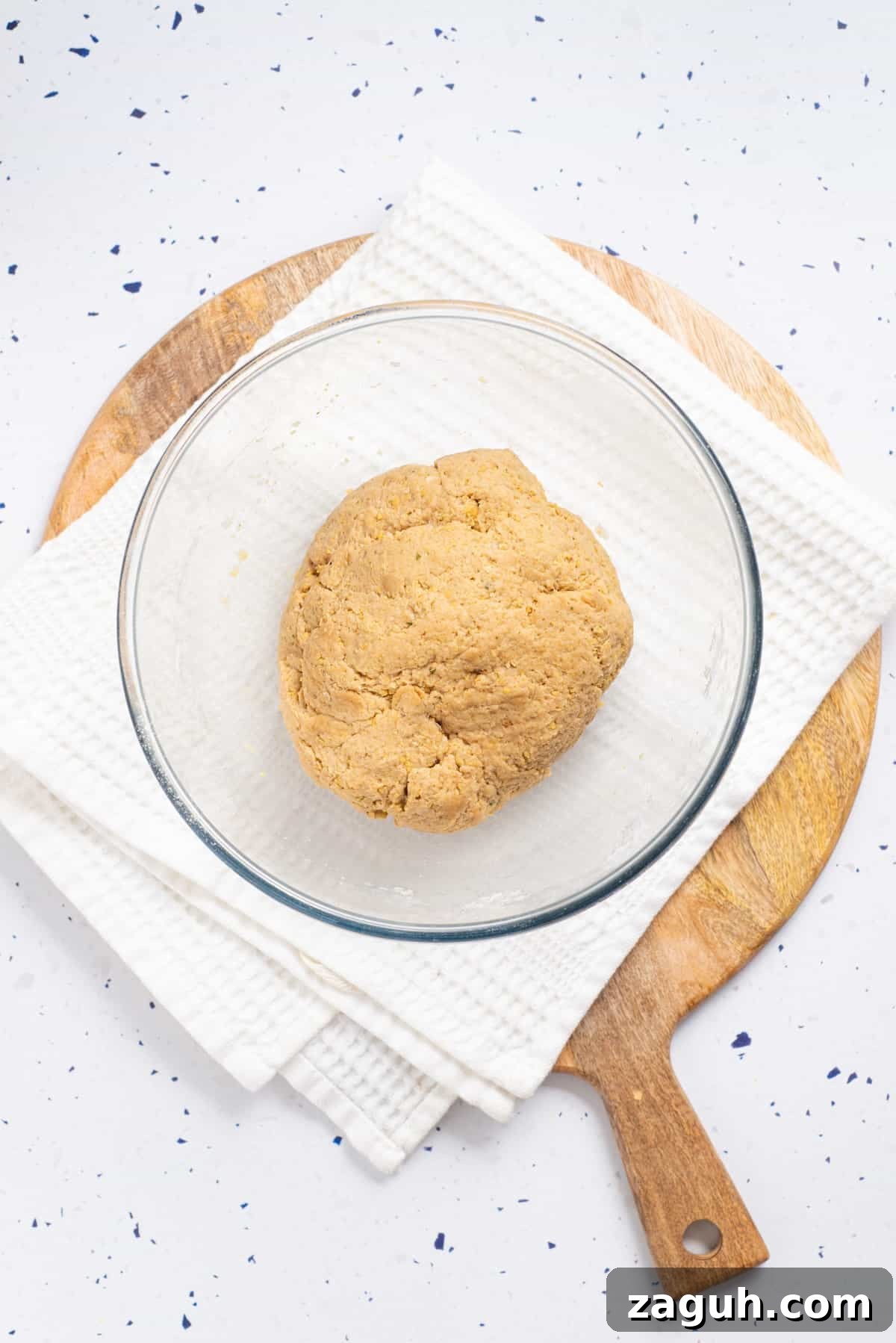 Overhead view of a kneaded mixture of vegan drumsticks placed on a transparent bowl.