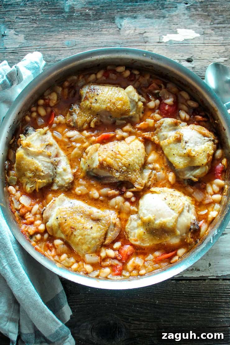 Garlic-Roasted Chicken with Creamy White Beans casserole 2 Overhead of chicken and white beans in skillet.