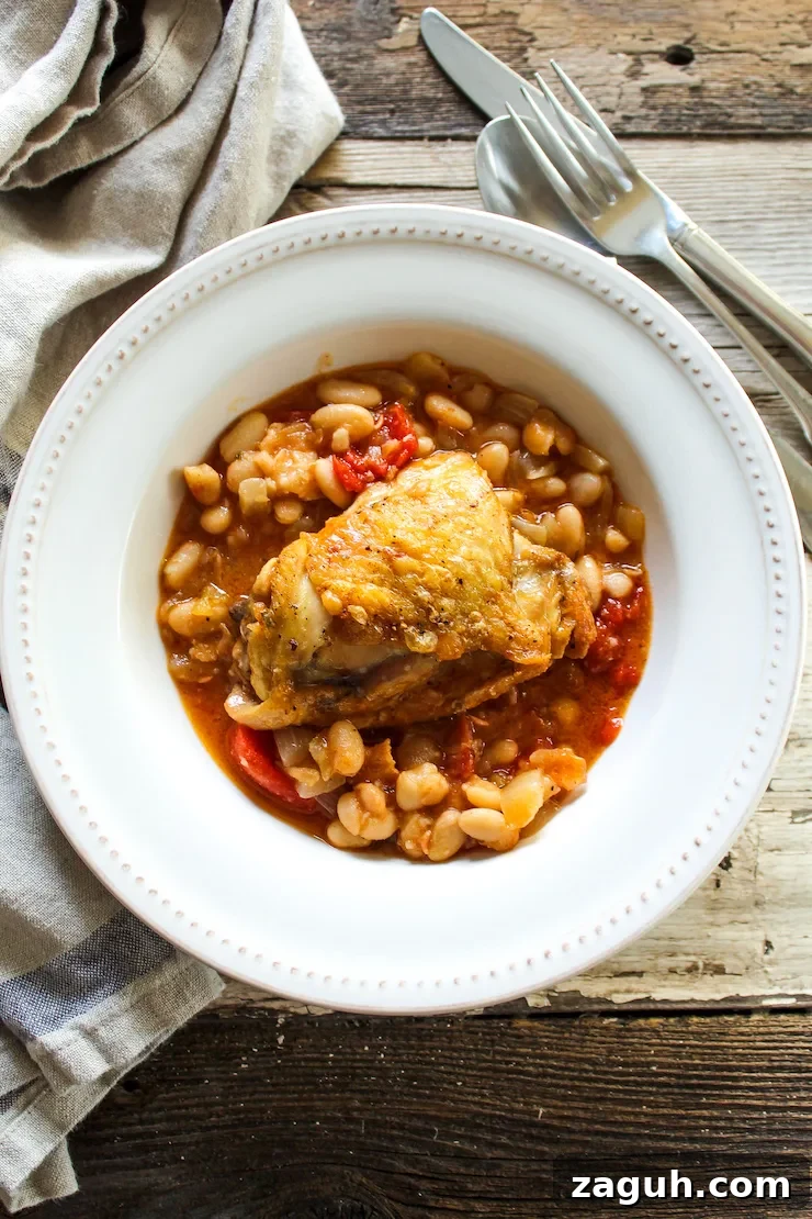 Garlic-Roasted Chicken with Creamy White Beans casserole 4 Plated chicken thigh over white beans.