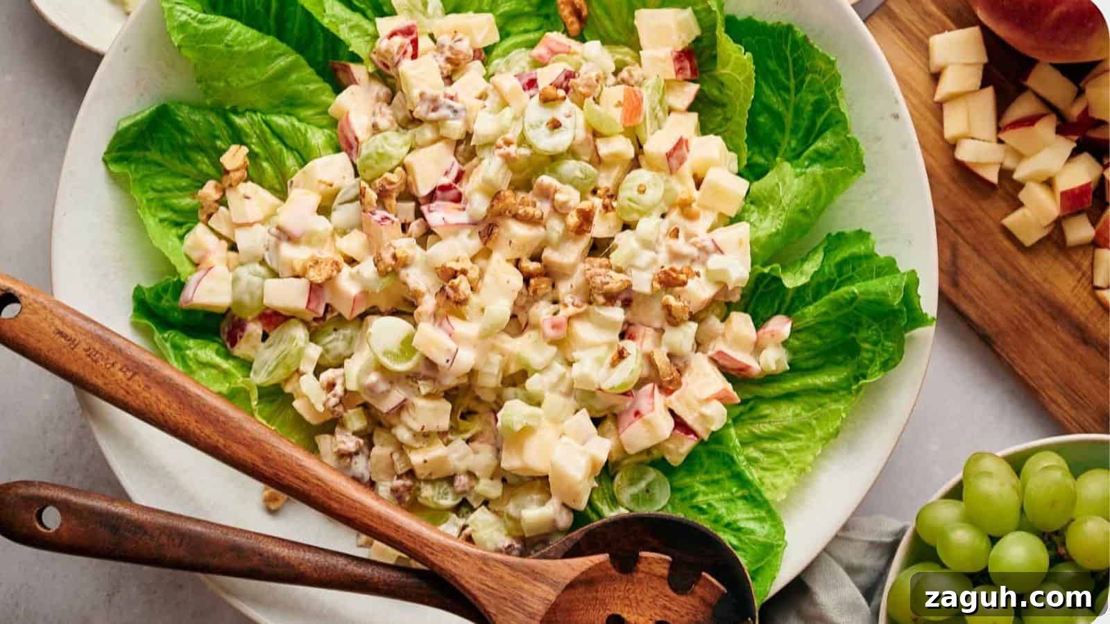17 Show-Stopping Potluck Recipes That Steal the Spotlight 18 Waldorf salad on a bed of lettuce, with salad servers resting on top.