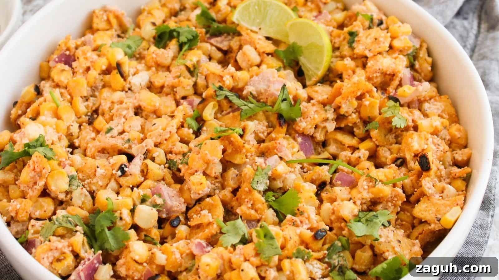 17 Show-Stopping Potluck Recipes That Steal the Spotlight 3 A bowl of Mexican street corn salad garnished with lime wedges and cilantro.