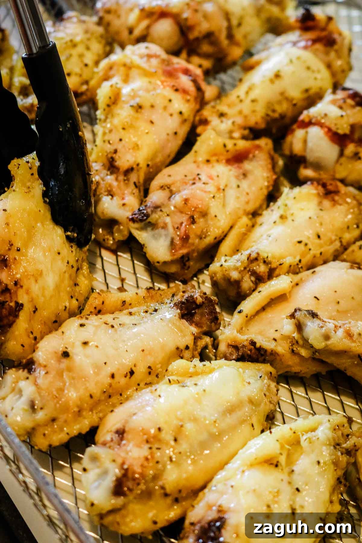 Crispy Baked Salt-and-Pepper Chicken Wings Recipe 7 flipping the chicken wings with black tongs.