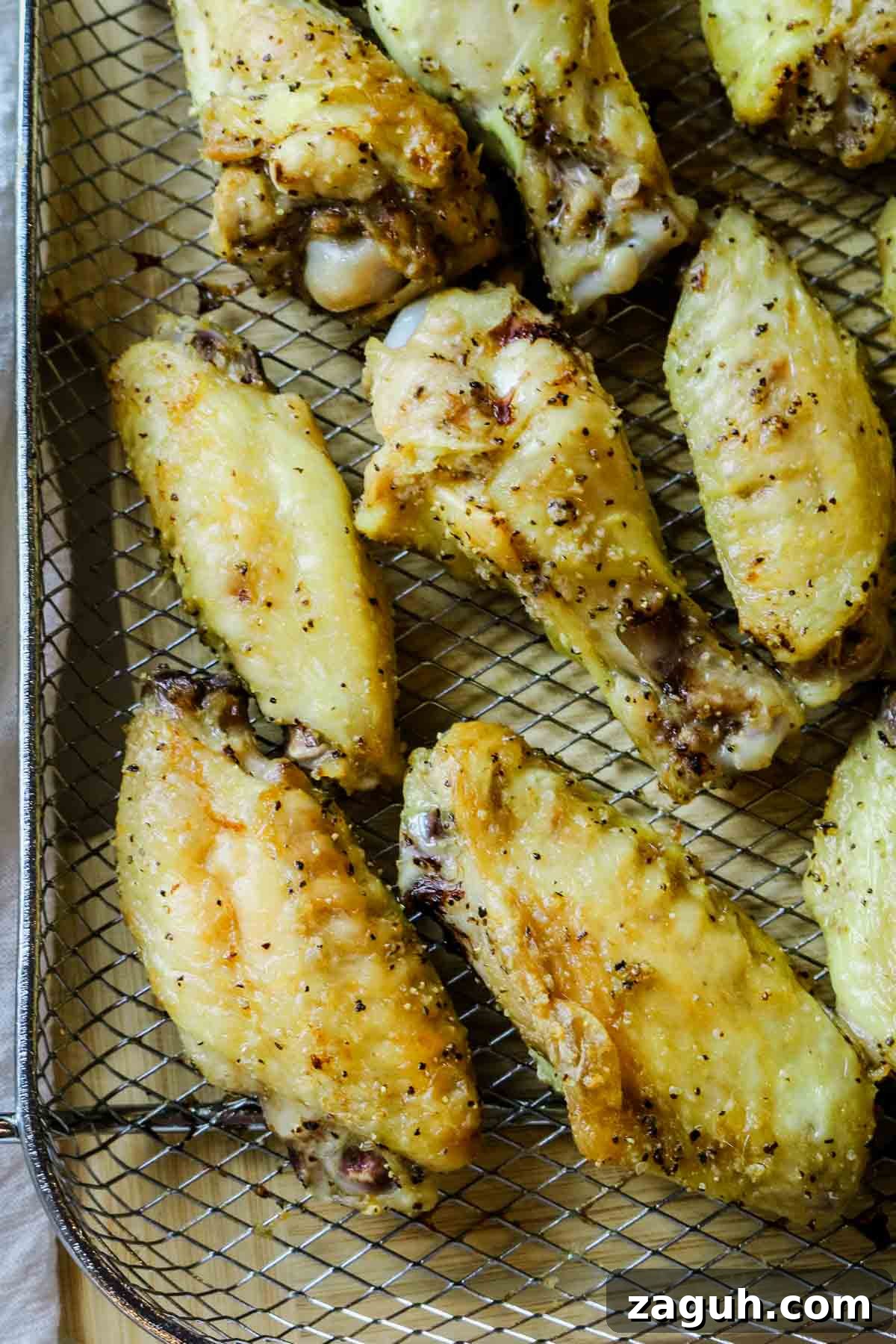 Crispy Baked Salt-and-Pepper Chicken Wings Recipe 9 chicken wings spread out on crisper tray.