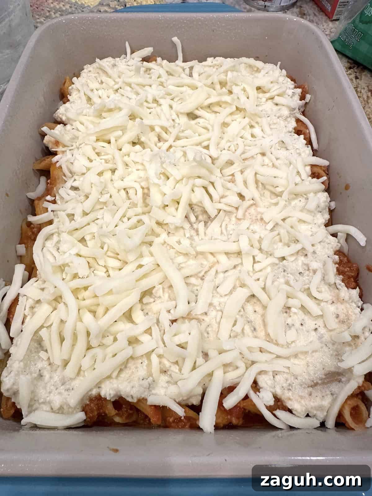 Quick No-Fuss Lasagna Recipe for Busy Weeknights 11 Mozarella cheese and ricotta on top of pasta noodles in a baking dish.