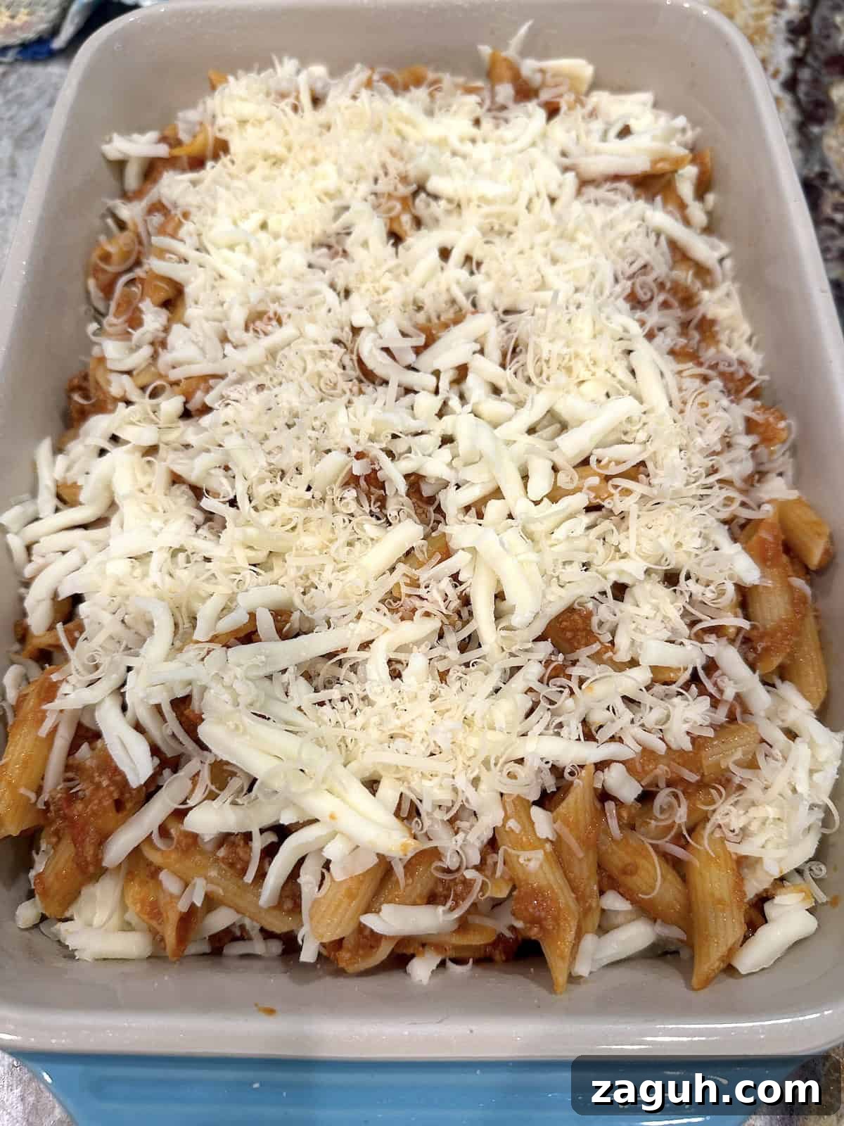 Quick No-Fuss Lasagna Recipe for Busy Weeknights 13 Unbaked lazy lasagna in a baking dish with mozzarella cheese on top.