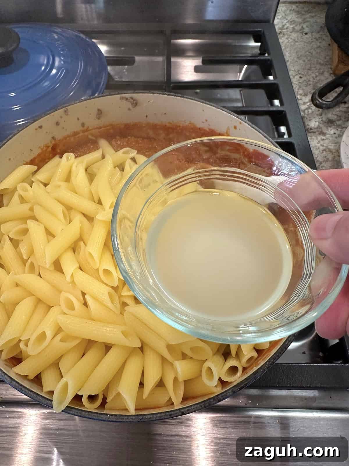 Quick No-Fuss Lasagna Recipe for Busy Weeknights 5 Cooked pasta and sauce for lazy lasagna in a pan with a cup of pasta water.